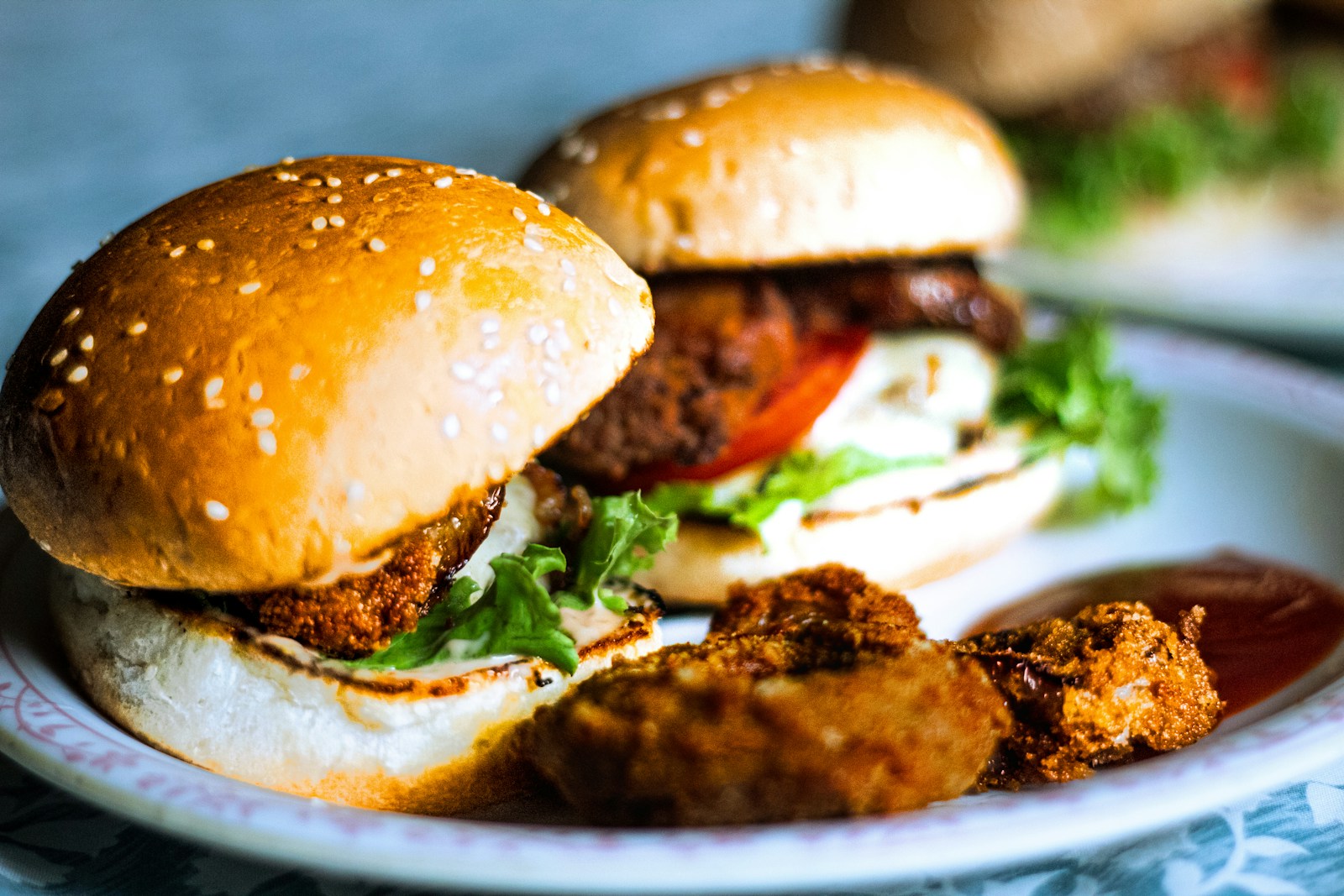 A plate with two burgers and some fried food on it